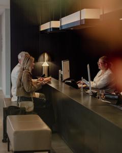 a group of people sitting at a counter at Hotel de Blanke Top in Cadzand-Bad +77 photos