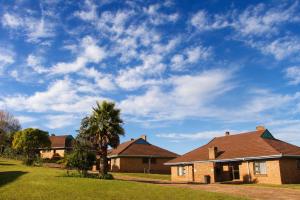 a brick house with a palm tree in a yard at Mogodi Lodge in Graskop