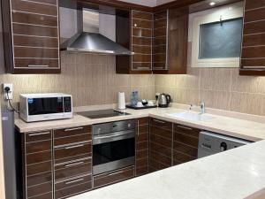 a kitchen with a microwave oven and a sink at Mandarin Alshamal Hotel Apartments in Riyadh