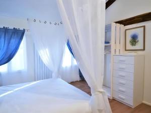 a bedroom with a bed with white curtains at La Corte di Marga Ginetta 2 - Prosecco Hills Holidays in Miane +35 photos