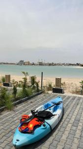 a kayak sitting on a sidewalk next to a beach at Villa with private Pool A in Al Khīrān