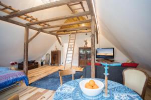 a room with a loft bed and a table with a bowl of fruit at Denkmal Haus Hugo in Medebach