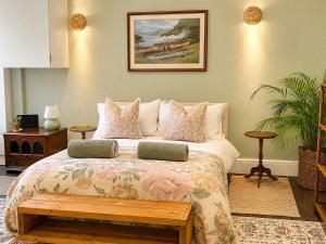 a bedroom with a bed with a bench on it at The Fig Tree in Brecon