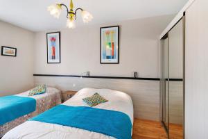 a bedroom with two beds and a chandelier at Gite Echo in Salignac Eyvigues +18 photos