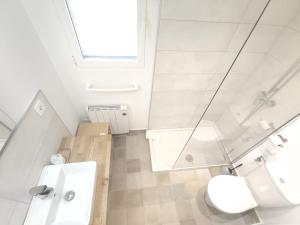 a white bathroom with a toilet and a sink at Casa Toronzue in Frajén