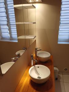 a bathroom with two sinks and a mirror at Au Thiernois in Thiers +8 photos