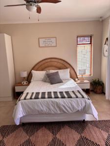 a bedroom with a large bed and a ceiling fan at Cottage Hill in Gqeberha