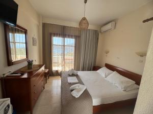 a bedroom with a bed and a desk and a window at Olive Grove in Plakias
