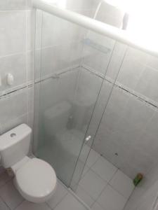 y baño con aseo y ducha acristalada. en Casa Dunas, en Florianópolis