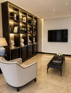 a living room with a couch and a tv and a table at Laodikya Hotel in Denizli