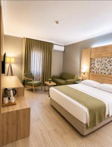 a bedroom with a large bed and a living room at Laodikya Hotel in Denizli