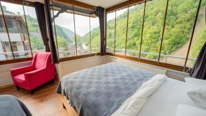 a bedroom with a bed and a chair and windows at 53 BRN hotel in Ardeşen +27 photos