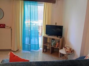 a living room with a tv and a window at Kyma studio Modern Stay in Nea Artaki