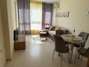 a living room with a table and a couch at Krasi Apartments in Perla Complex in Pomorie