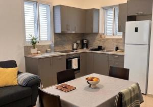 a kitchen with a table with a bowl of fruit on it at Tac-Coghki Maisonette in Rabat