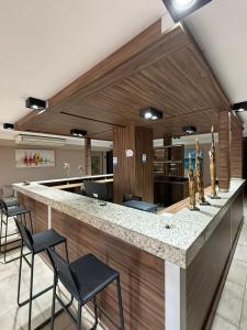 a lobby with a counter with chairs and a bar at Peko's Multiparque Hotel in Villa Santa Cruz del Lago