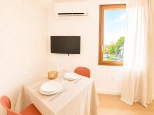 a dining room with a white table and a window at M114 Magnifique T2 aux portes de la douane de Moillesulaz in Gaillard +1 photo