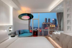 a bedroom with a bed and a view of a city at Aspera Star Essence Sky Garden Panoramic Hotel-Jiefangbei Hongya Branch in Chongqing