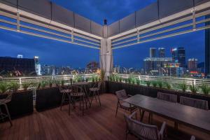 a balcony with tables and chairs and a city skyline at Aspera Star Essence Sky Garden Panoramic Hotel-Jiefangbei Hongya Branch in Chongqing