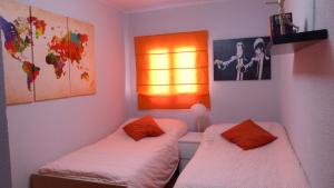 a bedroom with two beds and a light on the wall at Apartamento Aluche con parking gratuito in Madrid