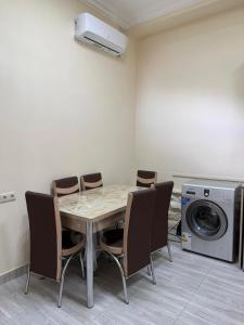 a dining room with a table and chairs and a washing machine at Guest House MD 2 in Tatʼev