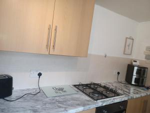 a kitchen with a stove and a sign on the counter at 3 Bedroom Apartment near the Beach in South Shields +10 photos