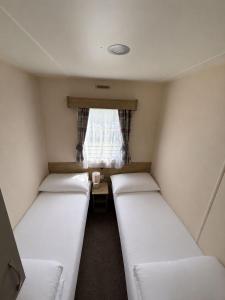 three beds in a small room with a window at Seaview Holiday Rentals - Arizona pet friendly in Chestfield +10 photos