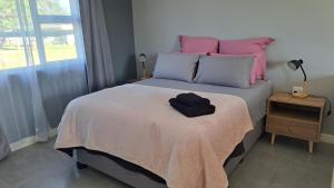 a bed with pink and blue pillows in a bedroom at Aqua Farm - Unit 3 in Teba