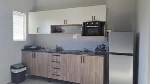 a kitchen with white cabinets and a refrigerator at Aqua Farm - Unit 3 in Teba
