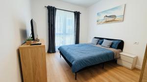 a bedroom with a bed and a flat screen tv at Diana Apartments in Arad