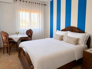 a bedroom with a large bed with blue and white stripes at Fori Vodo in Divjakë