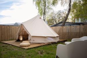 a tent in a yard with a fence at Maszoperia Sun4hel Kite & Wind & Surf in Jastarnia