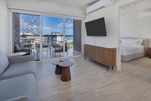 a living room with a couch and a tv at Olas del Mar by Playa Caracol Resorts in Palmira +176 photos