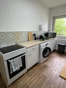 a kitchen with a stove and a washing machine at GM Zimmervermietung in Hamburg