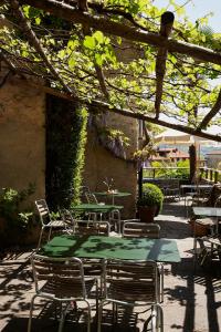 an outdoor patio with tables and chairs under an umbrella at Albergo Casa Santo Stefano in Miglieglia