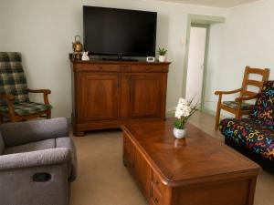a living room with a tv and a coffee table at La Parenthèse du Lot in Gramat