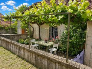 a pergola with a table and a bunch of grapes at La Parenthèse du Lot in Gramat