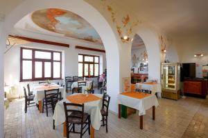 a restaurant with tables and chairs in a room at Guesthouse Rajski okusi Sveta Gora in Solkan
