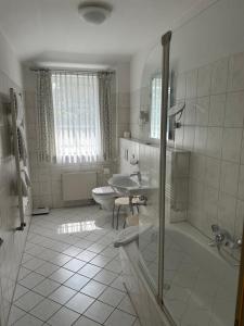 a bathroom with a sink and a toilet and a shower at Hotel-Marks-Garni in Zingst +104 photos