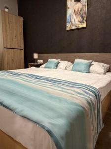 a large bed with a blue and white blanket at Mnd Aqua Nest in Zalakaros +14 photos