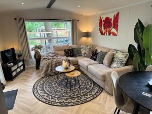 a living room with a couch and a table at El Bohemia Veluwe rust, natuur & zwembad voor kids in Hoenderloo