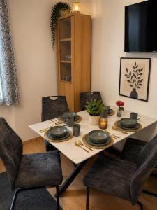 a dining room with a table with chairs and a television at Niklasdorf Bergblick/Erholung in Niklasdorf