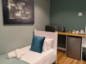 a room with a bed with a blue pillow on it at Bel-Air Guesthouse in Klerksdorp