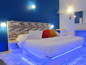 a bedroom with a large white bed with a brick wall at SeaLaVie Inn in Ukulhas