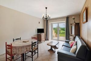 a living room with a table and a blue couch at Gîte Charly in Salignac Eyvigues