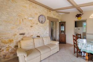 a living room with a couch and a clock on the wall at Gite Sierra in Salignac Eyvigues