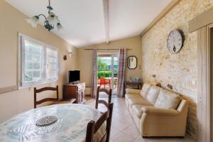a living room with a couch and a table at Gite Sierra in Salignac Eyvigues