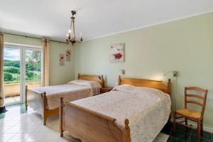 a bedroom with two beds and a chair and a window at Gite Sierra in Salignac Eyvigues +18 photos