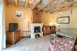 a living room with a couch and a television at Gite Four De Mon Père in Salignac Eyvigues