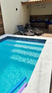 a swimming pool with blue water in a house at Pousada Morena Raiz in Ubatuba
